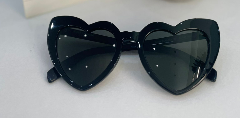 A pair of YSL heart-shaped sunglasses.]