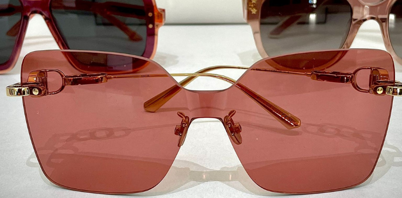 Three pairs of pink coloured Dior sunglasses in different styles.