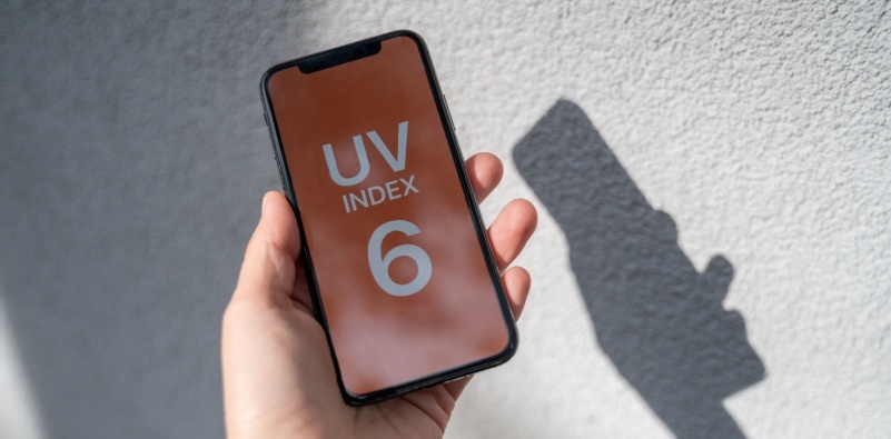 Person holding phone showing UV index level