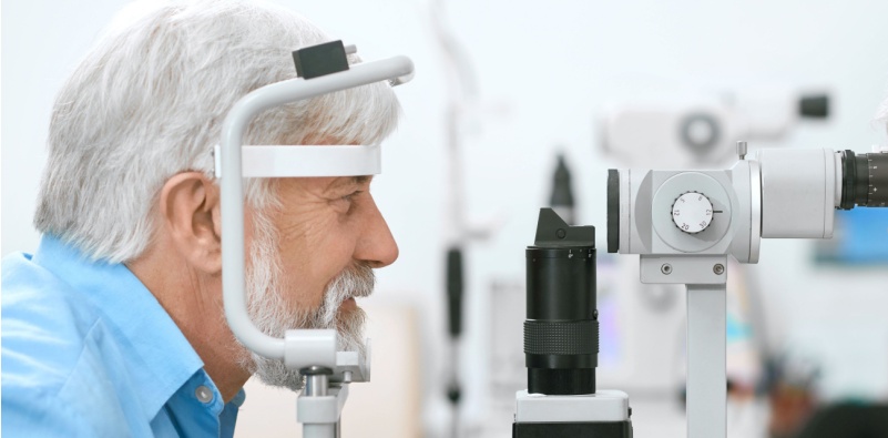 Optometrist performing an assessment on elderly man