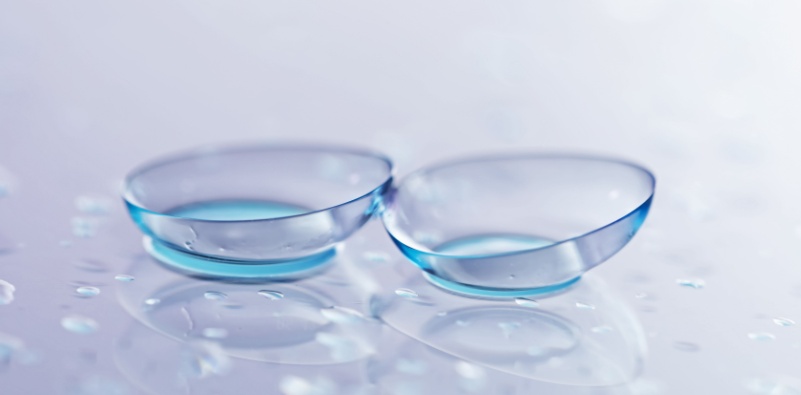 two contact lenses on a reflective surface