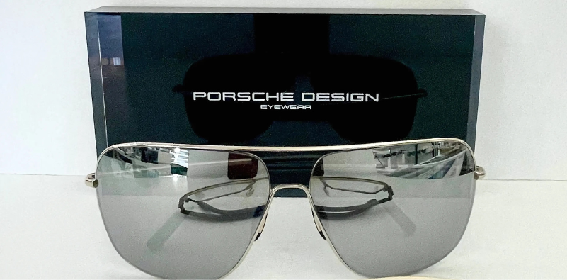 Porsche Design sunglasses displayed at an optician’s with Porsche Design branding in the background.]