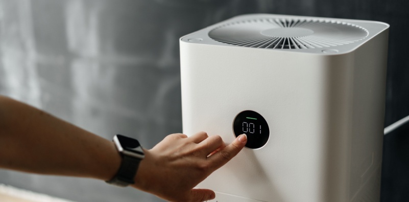 Person adjusting an air purifier