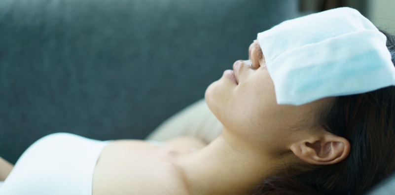 Woman resting with a cold compress over her eyes