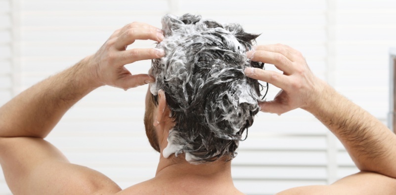 man rinsing hair in the shower