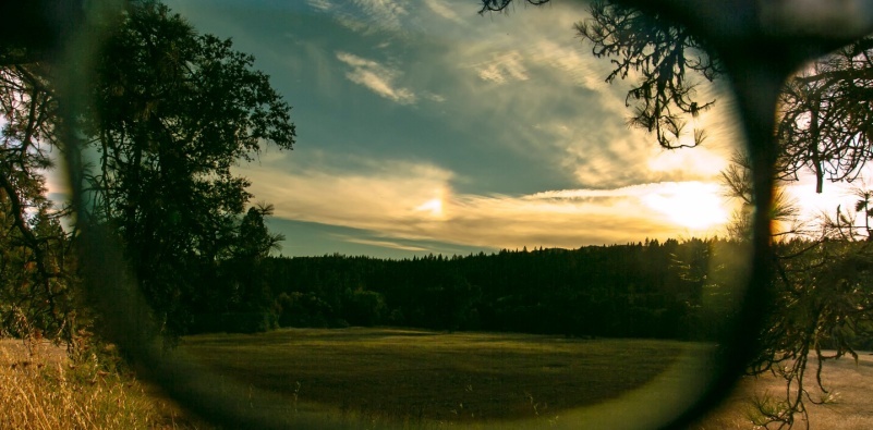 – A close up view through the lens of a pair of polarised sunglasses, showing the reduction in glare from the sun