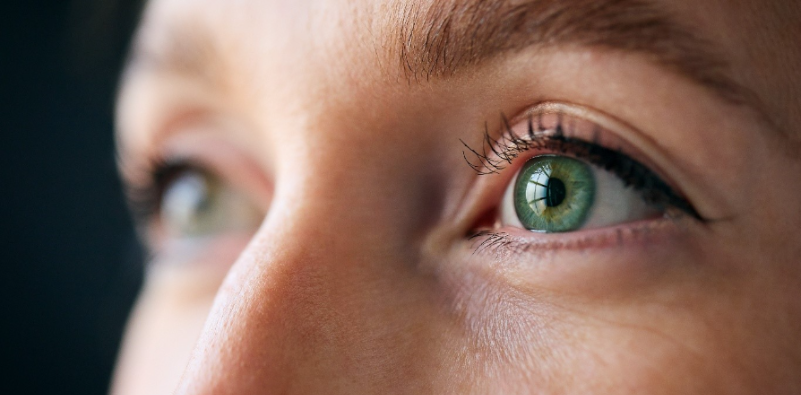 A close-up of a woman’s green left eye