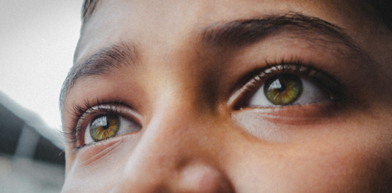 Close-up of a child’s green eyes looking upwards